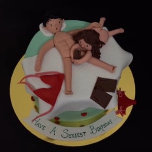 Funny adult birthday cake featuring 3D couple in bed with scattered clothes and "Have a Sexiest Birthday" text. Naughty custom cake delivery in Hyderabad, Banjara Hills, and Jubilee Hills.