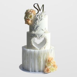 3-tier white engagement cake with bas-relief flowers, heart cutout, vertical ruffles, and peach roses. Luxury custom wedding cake delivery in Hyderabad, Banjara Hills, and Jubilee Hills.