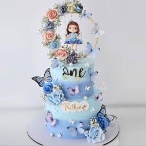 Blue 2-Tier First Birthday Cake with Butterflies and Doll Topper